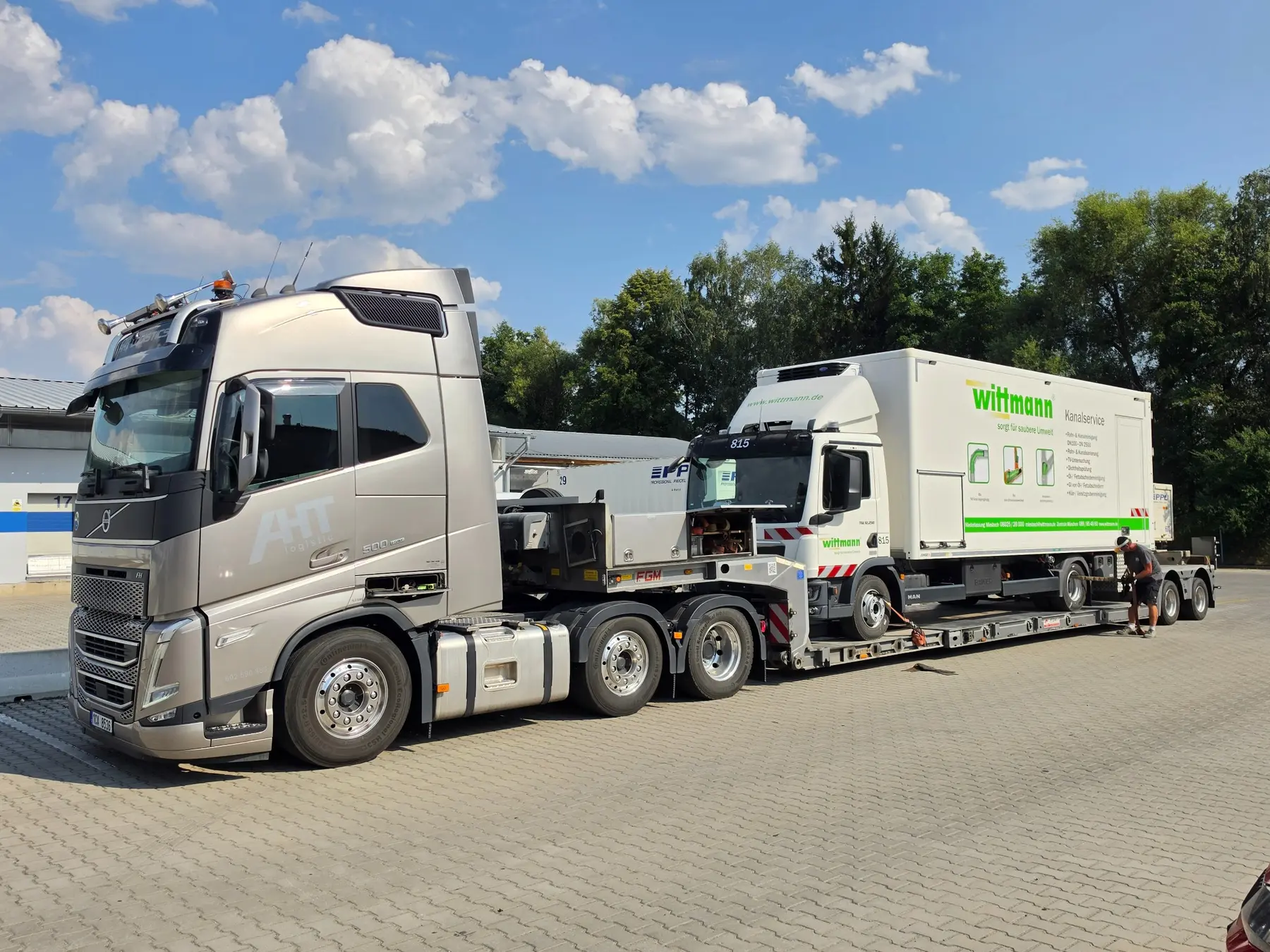 Nákladní souprava Volvo převážející polepený servisní vůz Wittmann