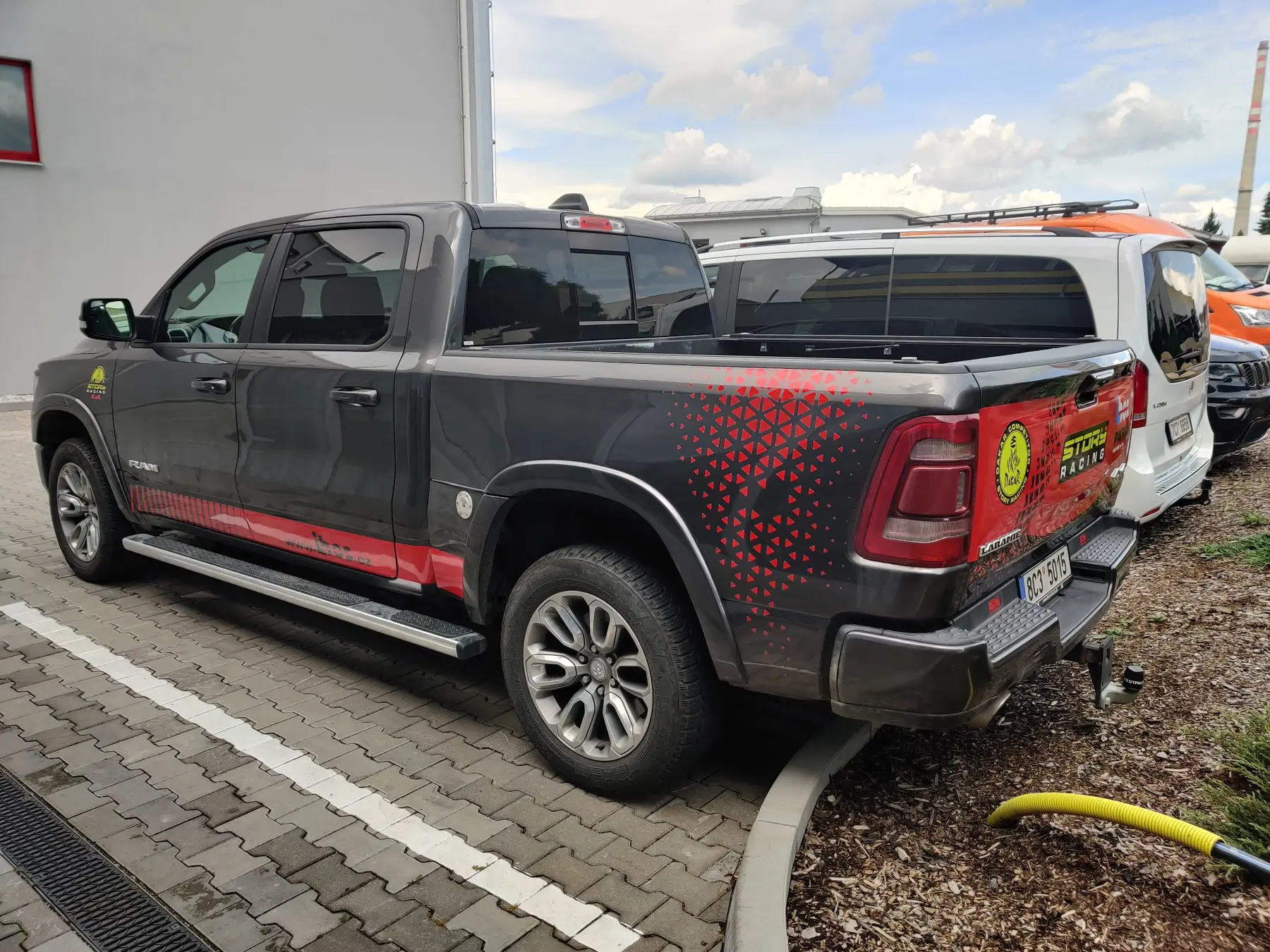 Červenočerný reklamní polep šedého pick-upu RAM pro Stone Racing